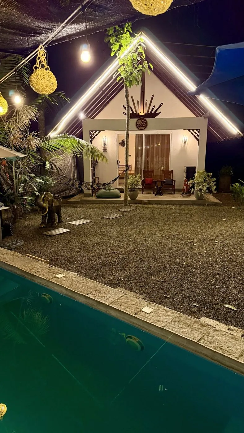 The plunge pool in front of the cottage, under strings of rattan lanterns