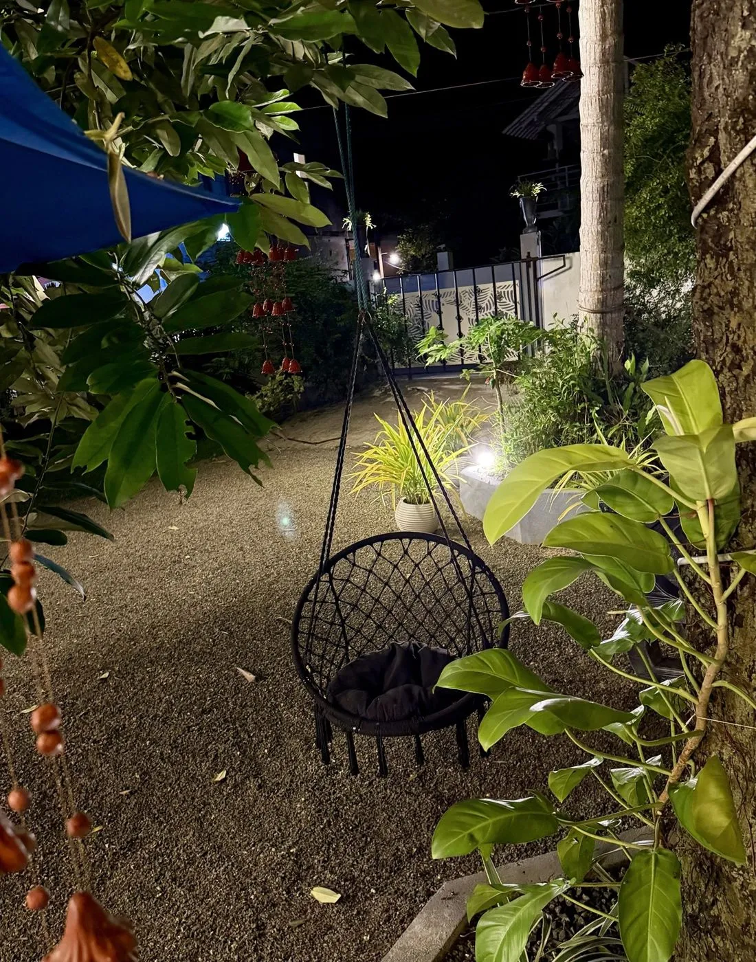 Hanging macramé swing chair in the leafy garden