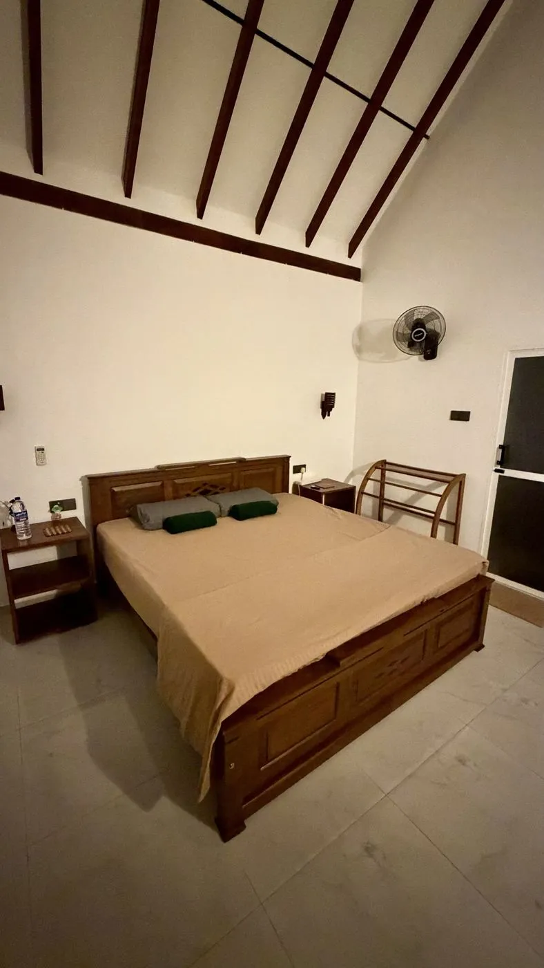 Bedroom with a high timber-beamed ceiling and a big teak bed