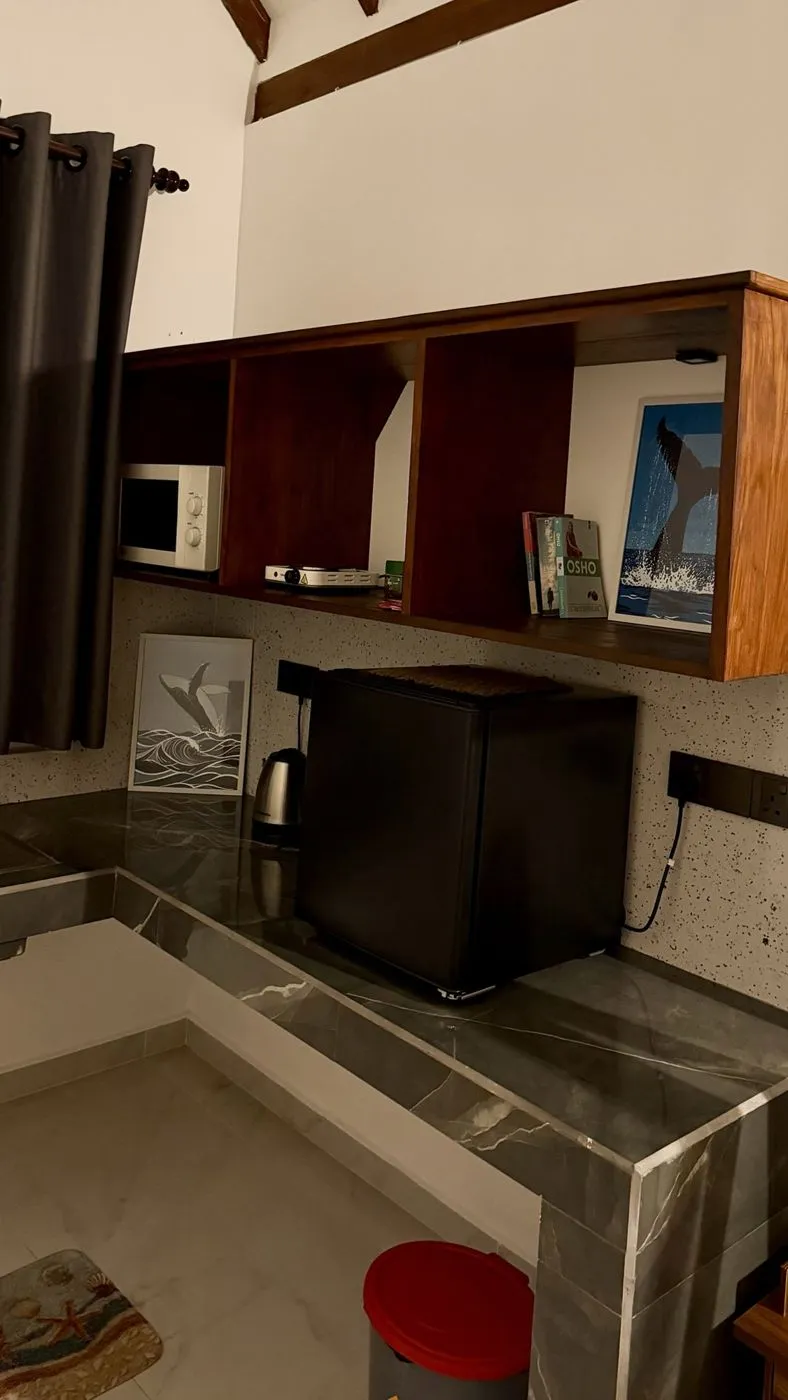 Whale prints and a little shelf of Osho books in the kitchen