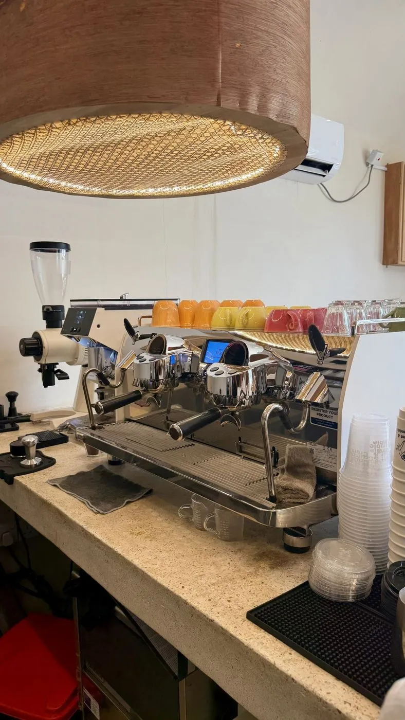 The espresso machine under a rattan lamp
