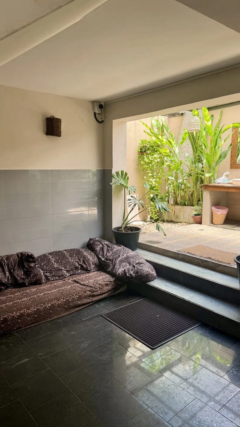 A cool, shaded lounge with floor cushions by the courtyard steps