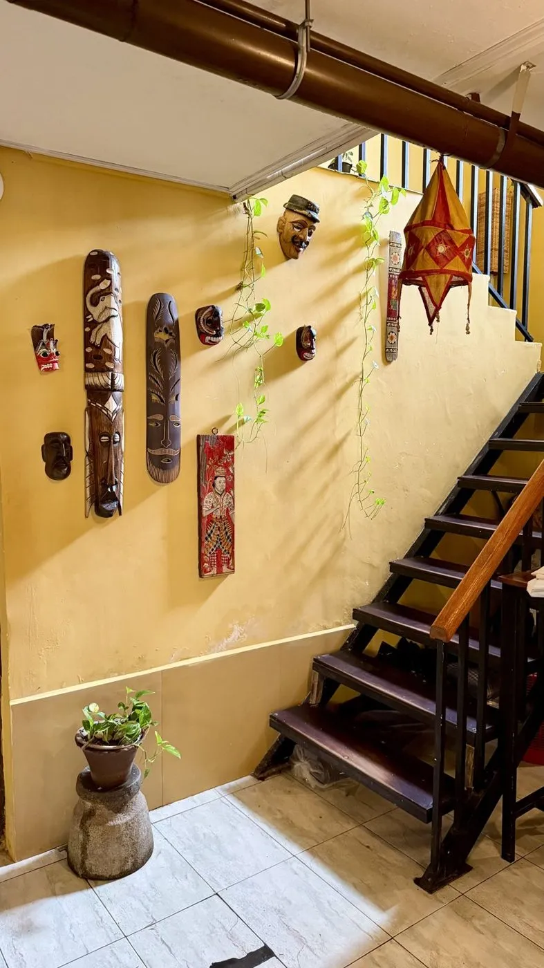 Carved wooden masks and a paper lantern by the stairs