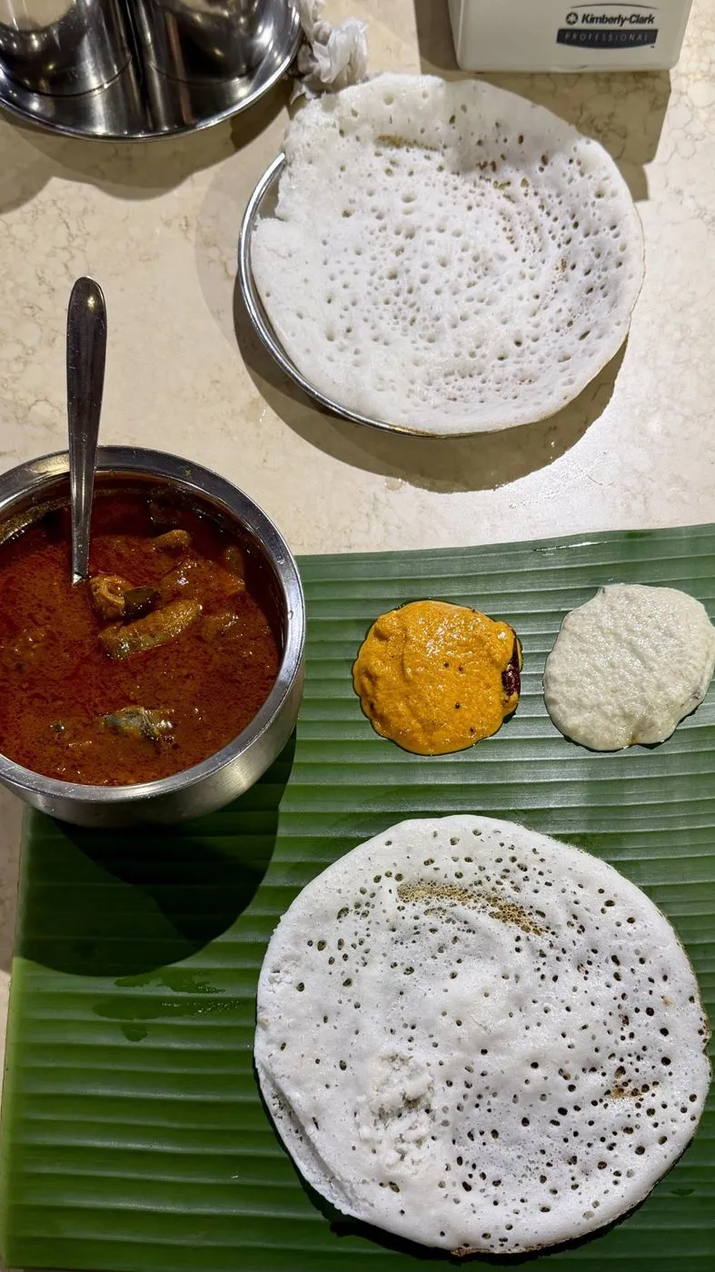 Dosas on a banana leaf with chutneys and curry