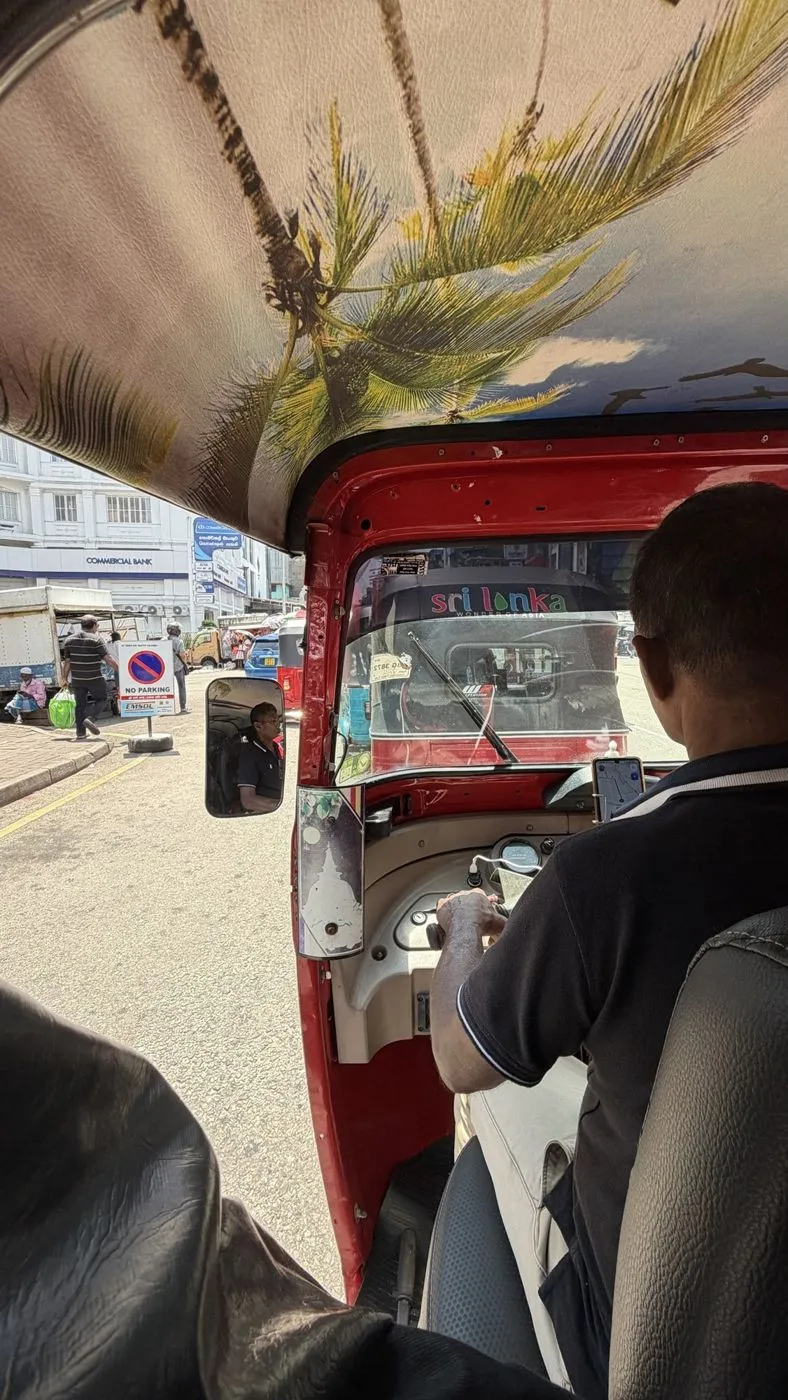 Palm-tree roof, a 'Sri Lanka, Wonder of Asia' tuk ahead and Colombo traffic