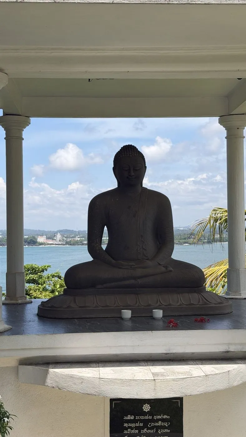 Stone Buddha looking out across the bay to Galle Fort