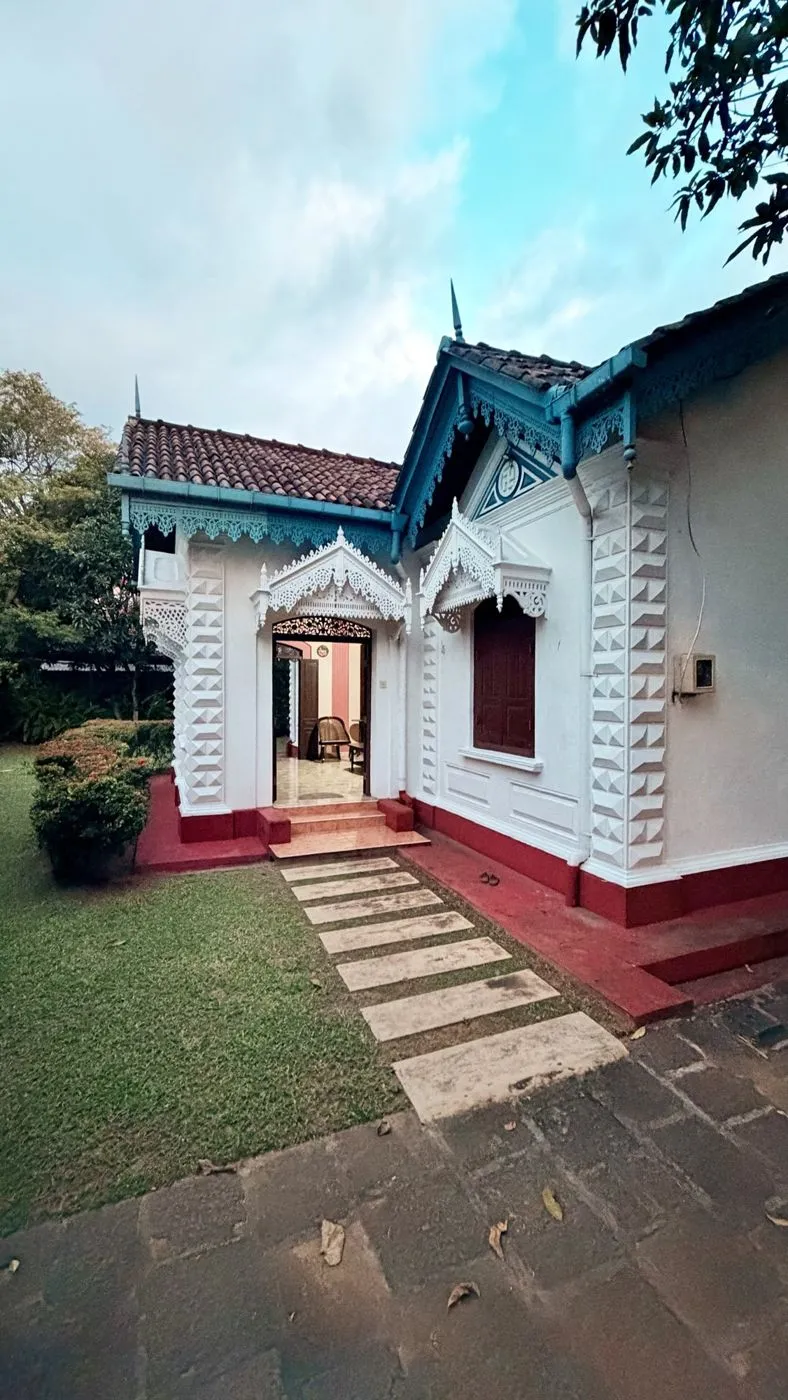 Old Parkland's colonial bungalow, with white fretwork, a terracotta roof and a red plinth