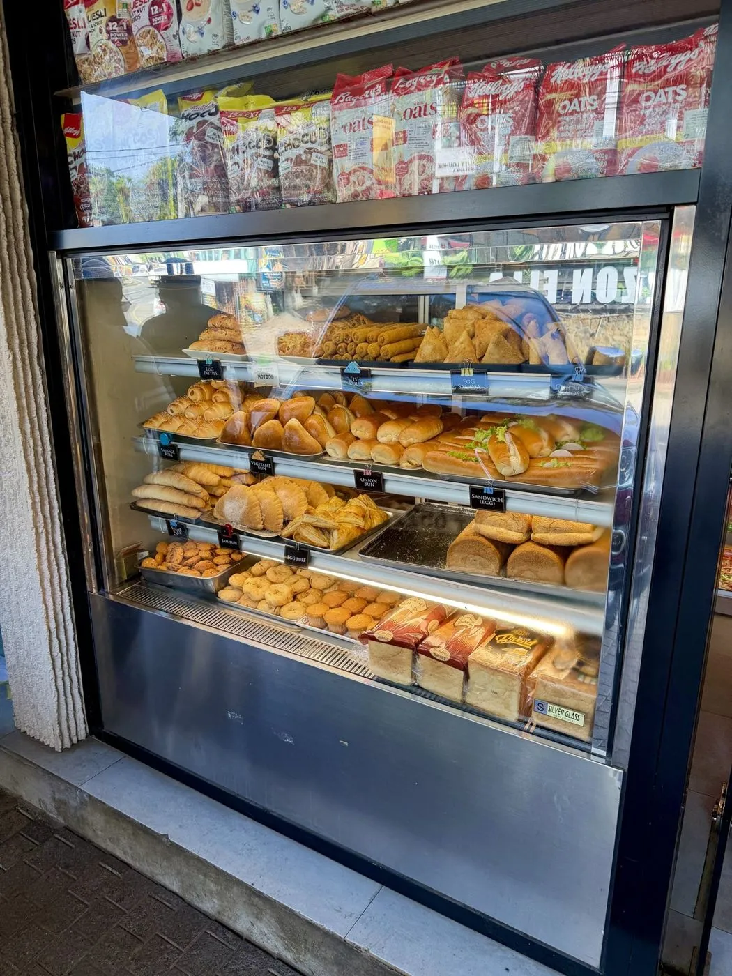 The short-eats case: fish rolls, egg patties, egg samosas, chicken rolls, cheese hotdogs, sausage rolls, vegetable and onion buns, egg sandwiches, sugar and jam buns, egg puffs, cookies and cupcakes