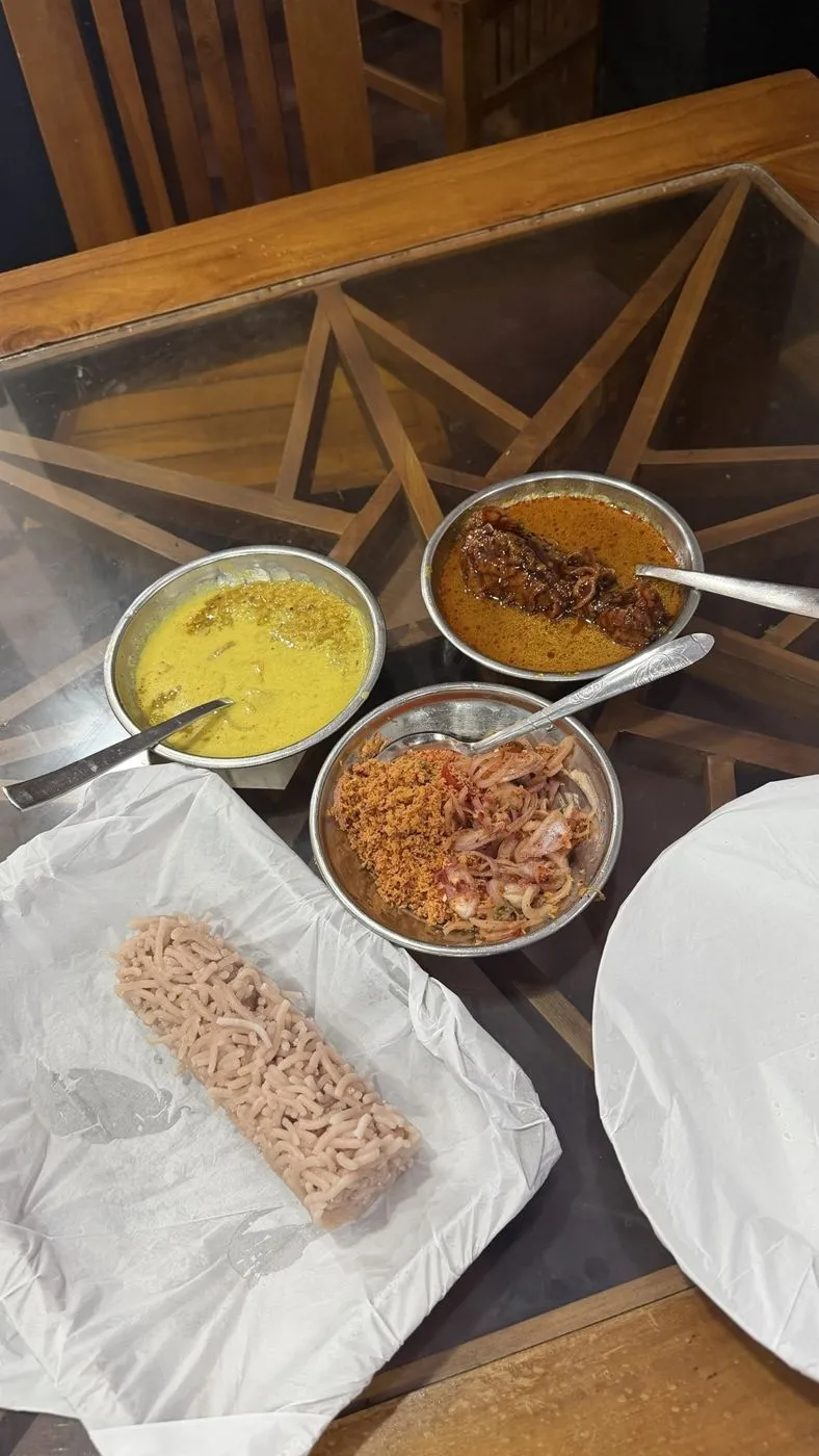 Red string hoppers with curries, pol sambol and onion sambol at a local shop
