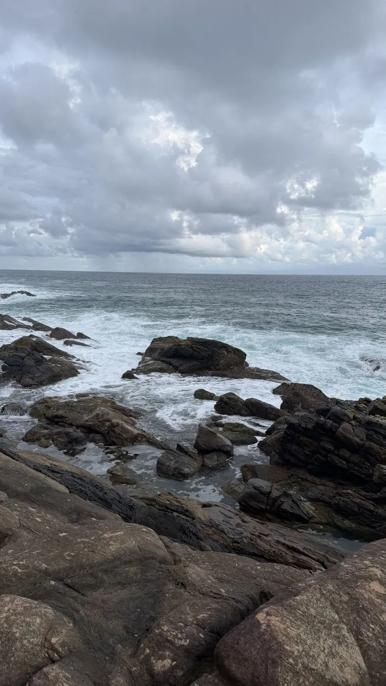 Rock pools and white water under a grey sky