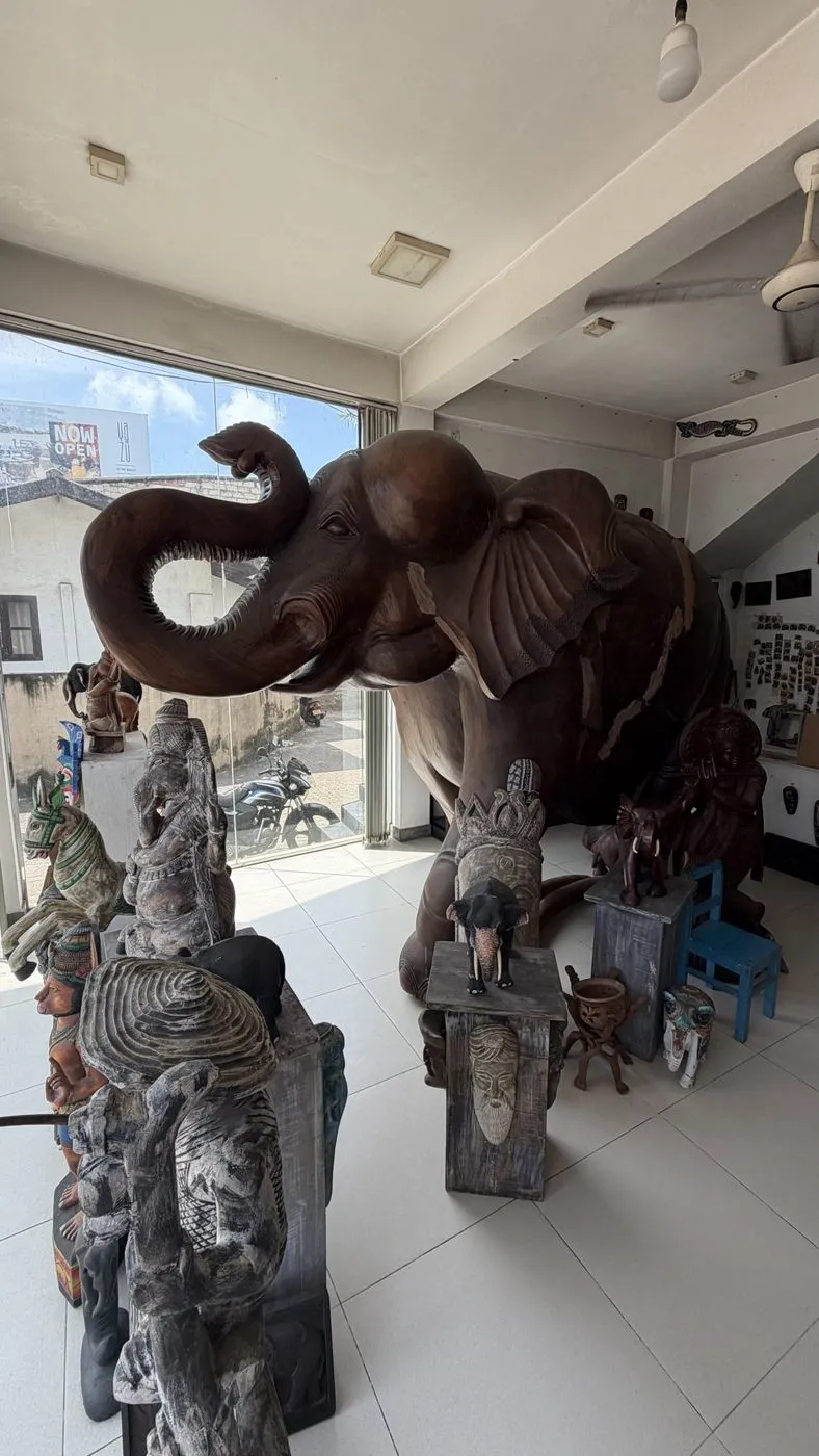 A life-size carved wooden elephant in the shop window